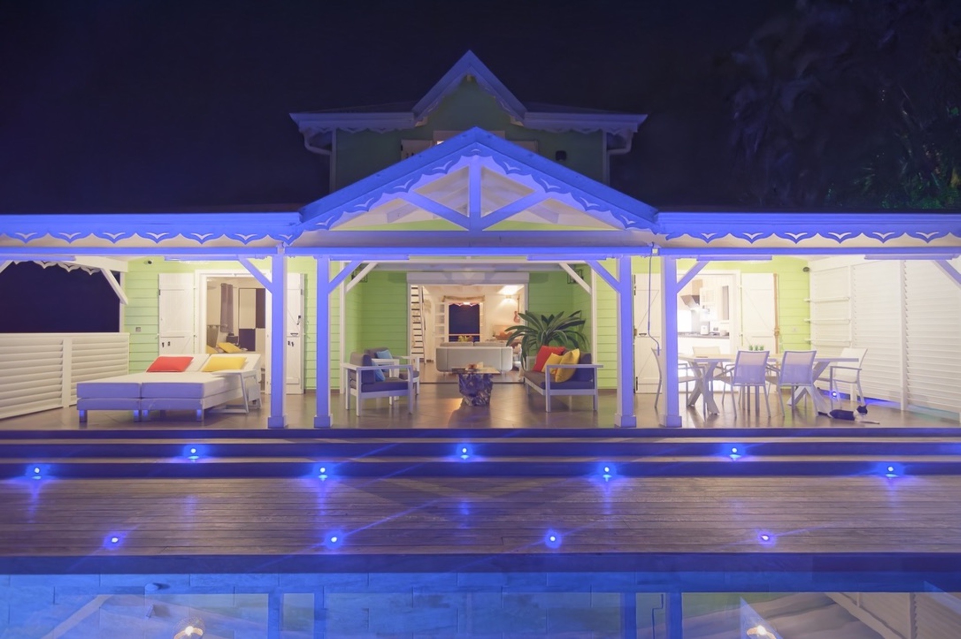 Façade créole illuminée — vue piscine